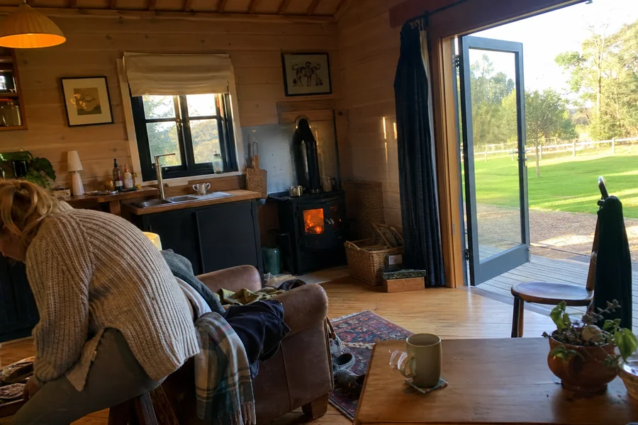 The Stables cabin interior with wood fire, kitchenette and garden doors